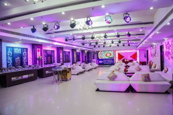 Grand banquet hall with stage lighting, buffet setup, and elegant seating at Krishan Shudhama Palace