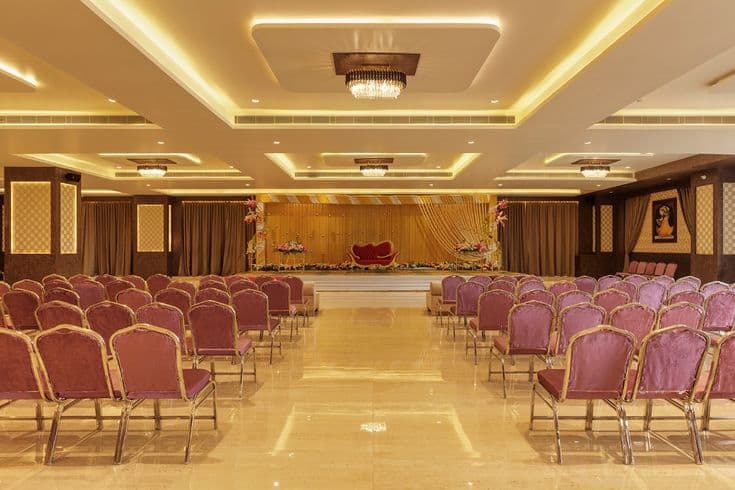 Formal banquet seating arrangement with stage and warm ambient lighting